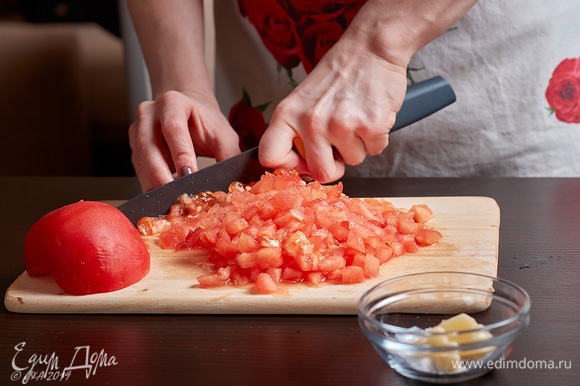 Бланшированные помидоры нарежьте мелким кубиком.