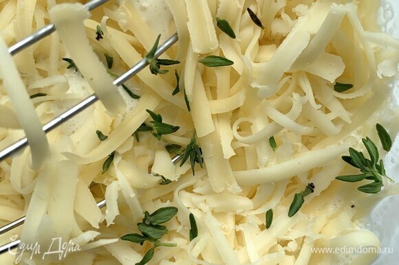 Приготовьте сливочную заливку. Яйца взбейте со щепоткой соли, добавьте сливки, натрите сыр на крупной терке и положите листочки свежего тимьяна.