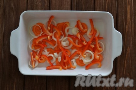 В форму для запекания выкладываем вторую нарезанную кольцами луковицу, очищенный от семян, нарезанный соломкой болгарский сладкий перец и кружочки моркови.
