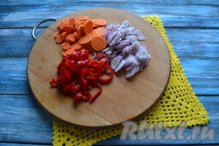 Очистить и вымыть овощи. Морковь и лук нарезать тонкими кольцами, а болгарский и острый перцы - соломкой. С острого перца необходимо тщательно вынуть косточки.
