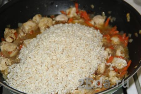 В рис впитается вся вода. Выложить рис в сковороду к овощам, обжаренным с куриной грудкой, перемешать.