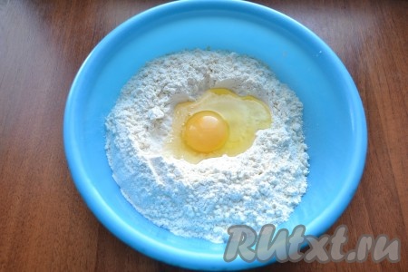 В миску насыпать муку. В муке сделать углубление, добавить соль и сырое яйцо.
