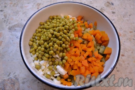 Отварную морковь, яйца очистить и тоже нарезать кубиками, добавить в салат вместе с консервированным горошком (без жидкости).
