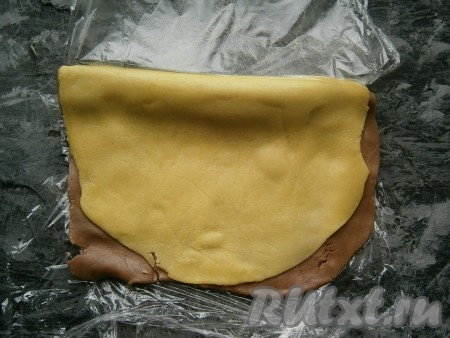 Затем тесто перевернуть (не свернутой половиной к себе и светлой - кверху) и также свернуть тесто в плотный рулет до свернутой части.
