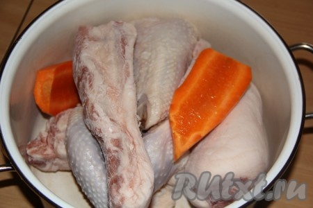 В кастрюлю выложить курицу и куски жирной свинины. Морковь очистить и добавить в кастрюлю.

