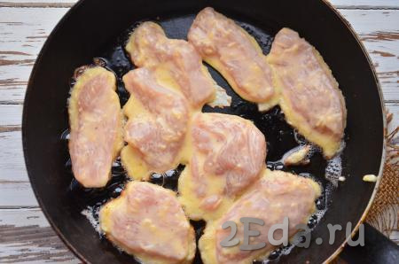 Несколько кусочков филе положите в миску с кляром. Затем аккуратно выложите мясо на сковороду в раскалённое рафинированное масло. Жарьте на слабом огне минут 5-7 с одной стороны.