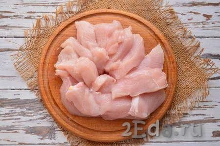 Охлаждённое куриное филе вымойте, салфеткой удалите лишнюю влагу. Нарежьте мясо на небольшие продолговатые кусочки одинаковой толщины.