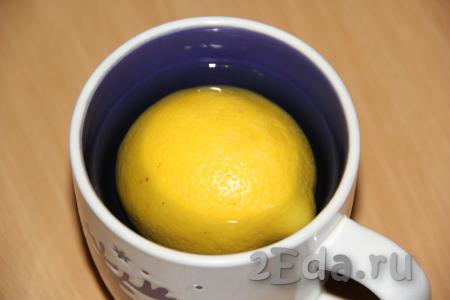 Лимон хорошо вымыть, поместить в большую кружку и залить крутым кипятком. Оставить лимон в кипятке на 10 минут.