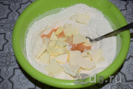 Далее оправляем в миску яйцо и охлаждённое сливочное масло, нарезанное на небольшие кусочки.