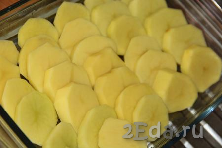 Картофель очистить и нарезать на кружочки. В форму для запекания (или на противень) выложить нарезанную картошку, слегка посолить.