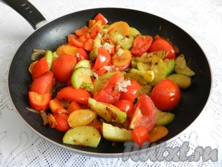 На растительном масле обжарить лук и морковь, затем добавить поочередно кабачок, перец и разрезанный на дольки помидор. Выдавить чеснок, посолить, добавить специи, немного воды, накрыть крышкой и тушить 15-20 минут до мягкости овощей.