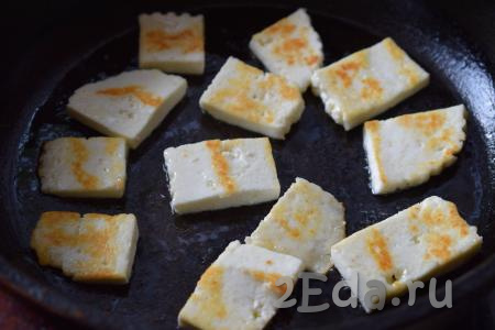 Далее нарезаем адыгейский сыр на квадратики. Разогреваем сковороду, наливаем в неё 1 чайную ложку растительного масла и выкладываем сыр. Обжариваем сыр до румяной корочки на среднем огне с двух сторон (примерно, по 2 минуты с каждой стороны).