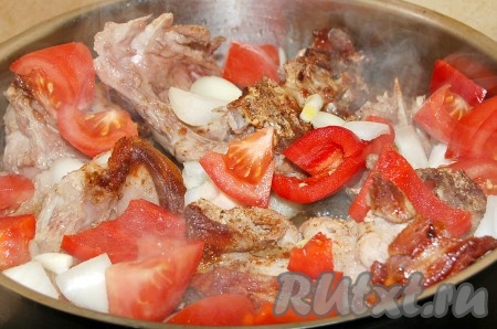 К обжаренным кусочкам индейки добавить нарезанные помидоры, сладкий перец и репчатый лук.