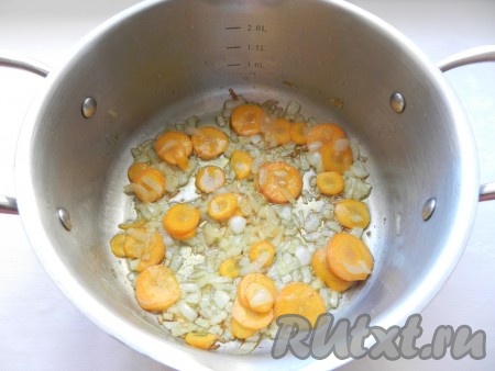В кастрюле с толстым дном разогреть растительное масло, добавить сливочное масло и обжарить лук и морковь до золотистого цвета.