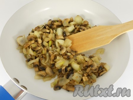 Влить в сковороду растительное масло и обжарить лук вместе с грибами до мягкости.
