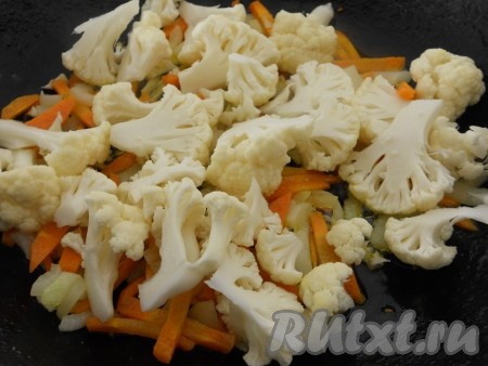 В сковороду к луку и моркови добавить соцветия сырой цветной капусты. Перемешать и обжаривать все вместе в течение 5 минут.
