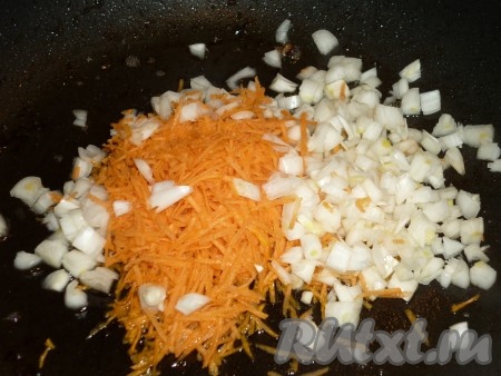 Обжаренные кусочки кролика переложить в кастрюлю, в которой будем в дальнейшем тушить мясо с картошкой. На масле, которое осталось на сковороде, обжарить нарезанный кубиками лук и натёртую на мелкой тёрке морковь. 