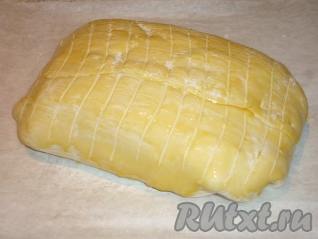 Завернуть мясо в тесто, выложить на противень, застеленный пергаментом, швом вниз. Сверху смазать взбитым желтком. Сделать с помощью ножа на тесте небольшие надрезы. 
