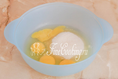 В другую посуду разбиваем куриные яйца, добавляем сахарный песок и ванилин (по желанию)