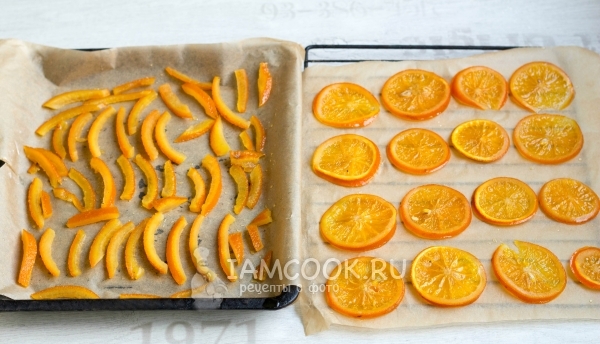 Выложить апельсиновые дольки и корки на противень