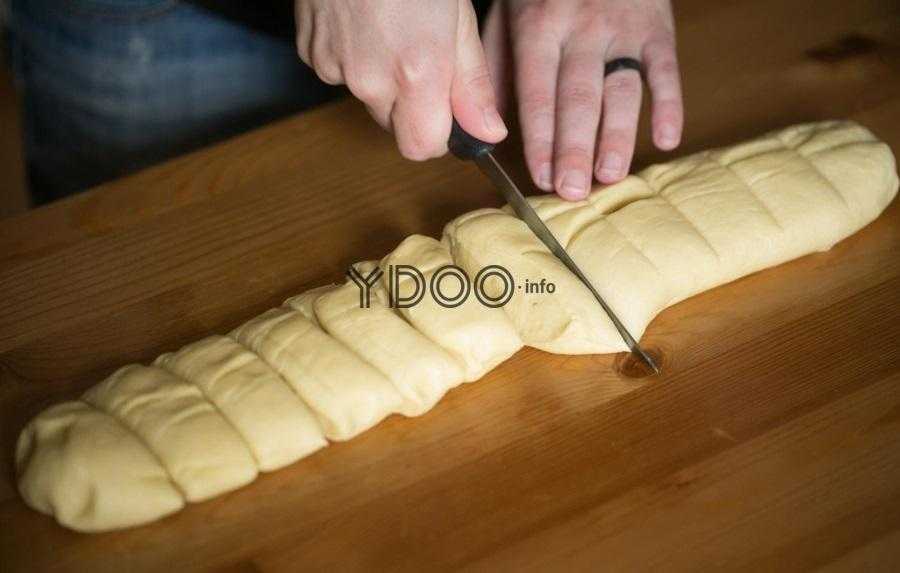 тесто, скатанное в колбаску, нарезается на кусочки острым кухонным ножом