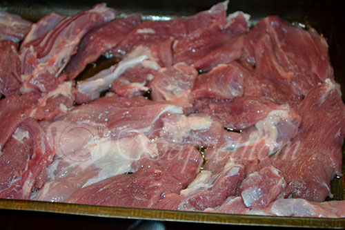 На дно формы для выпечки выкладываем свинину нарезанную пластинами.