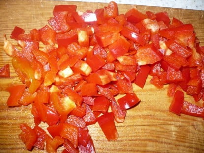 Мелко нарезать болгарский перчик и добавить к луку и моркови; пассеровать ещё минуту-две