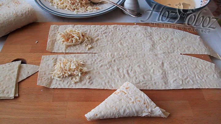 Чтобы сформировать треугольники, в самом начале полосы из лаваша выложим сыр