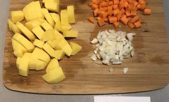Шаг 3: Пока варится булгур, нарежьте кубиками картофель, лук и морковь.