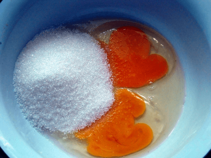 В миску вбить куриные яйца, добавить сахарный песок.