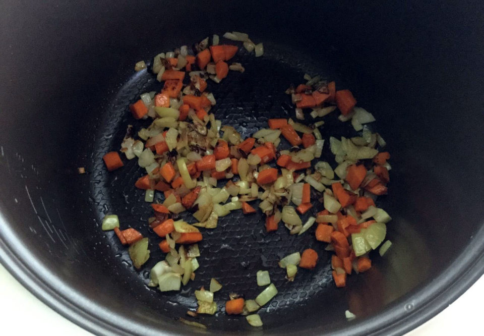 Наливаем немного растительного маста и в режиме «Обжаривание» доводим до полуготовности нарезанные кубиками лук и морковку.